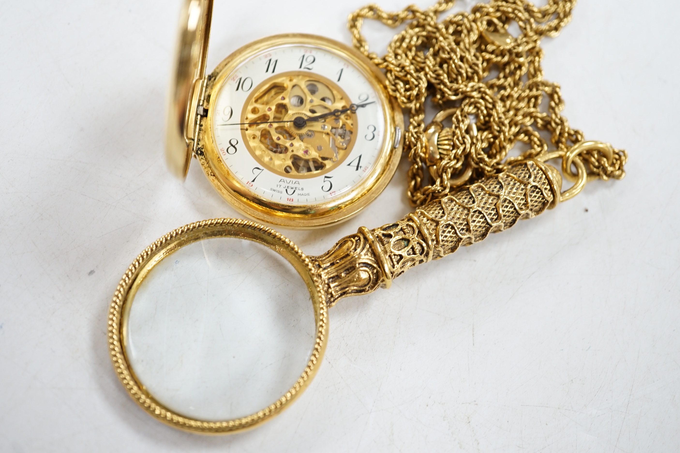 A gold plated Avia keyless pocket watch, on gilt chain with magnifying glass. Condition - fair